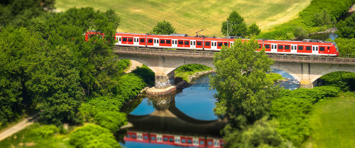 Zug fährt über Brücke in schöner Landschaft